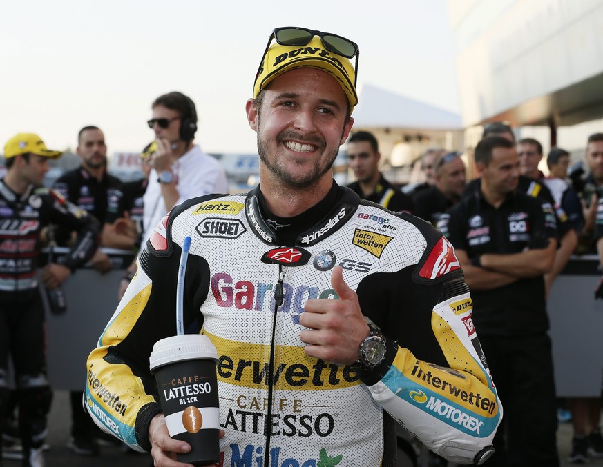 epa05586175 Swiss Moto2 rider Thomas Luethi (C) of Garage Plus Interwetten shows a thumb-up after after placing second in the qualifying of the MotoGP Grand Prix of Japan at Twin Ring Motegi, Tochigi  ...