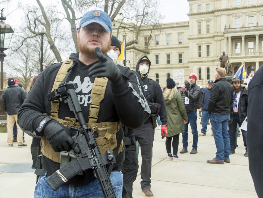 epa08364992 Protesters open carrying their firearms join in &#039;Operation Gridlock&#039; in front of the Michigan state Capitol in Lansing, Michigan, USA, 15 April 2020. The protest organizers, The  ...