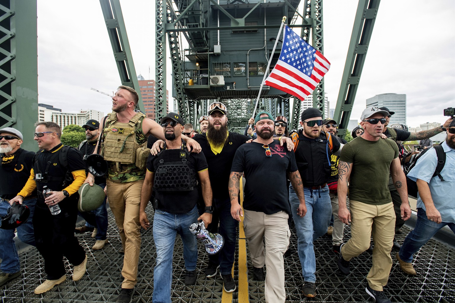 FILE - In this Aug. 17, 2019, file photo, members of the Proud Boys and other right-wing demonstrators march across the Hawthorne Bridge during a rally in Portland, Ore. The group includes organizer J ...