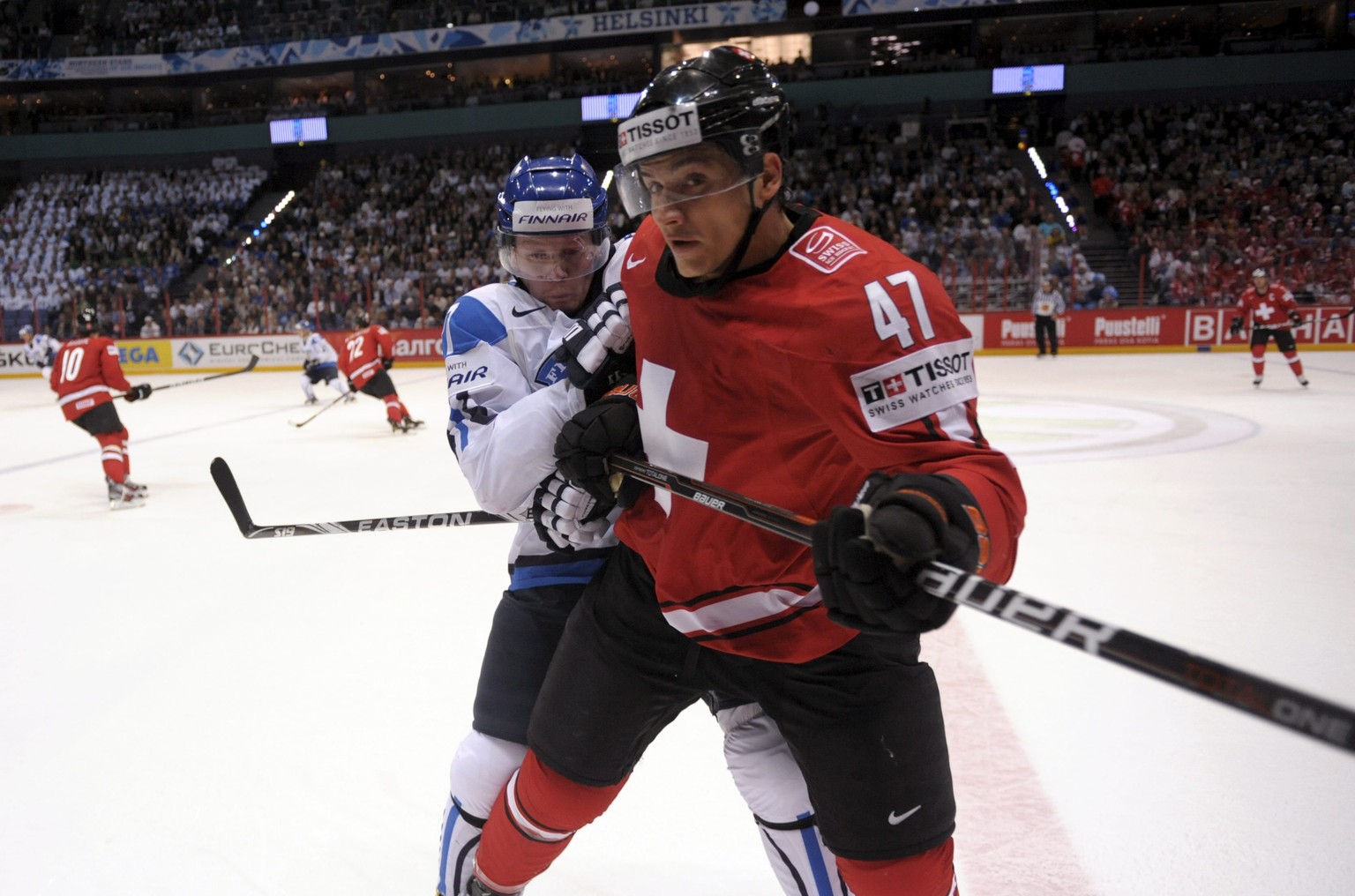 Finland&#039;s Petri Kontiola, rear, tackles Luca Sbisa of Switzerland during their Group H game Finland vs Switzerland of the 2012 IIHF Ice Hockey World Championships in Helsinki, Finland Tuesday, Ma ...