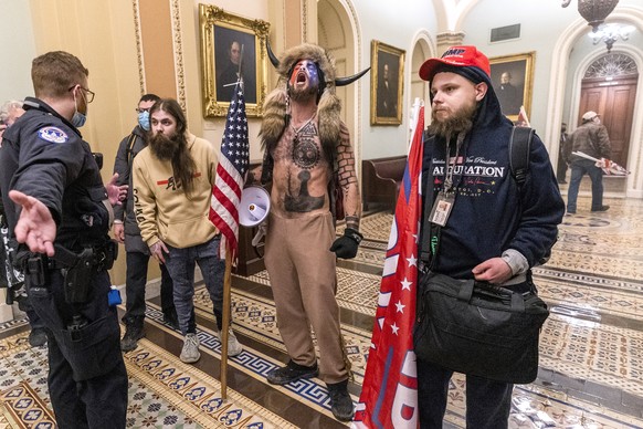 FILE - In this Wednesday, Jan. 6, 2021, file photo, supporters of President Donald Trump, including Jacob Chansley, center with fur hat, are seen during the riot at the U.S. Capitol in Washington. A f ...