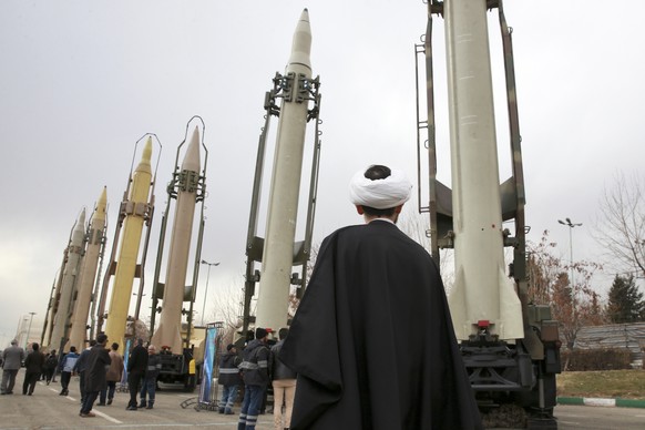 FILE - In this Feb. 3, 2019 file photo, an Iranian clergyman looks at domestically built surface to surface missiles displayed by the Revolutionary Guard in a military show marking the 40th anniversar ...