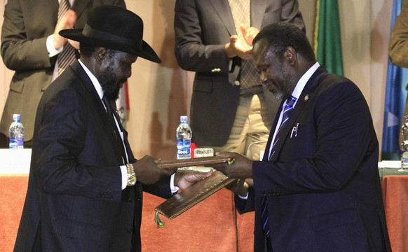 1. Februar 2015: Salva Kiir und Riek Machar tauschen Dokumente aus nachdem sie den Waffenstillstand unterzeichnet haben.
