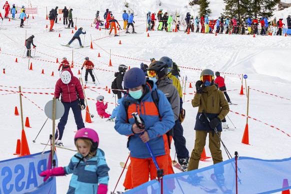 Skiers wait in a ski lift line with a setup promoting social distancing during the coronavirus disease (COVID-19) outbreak, in the alpine resort of Villars-sur-Ollon, Saturday, December 19, 2020. (KEY ...