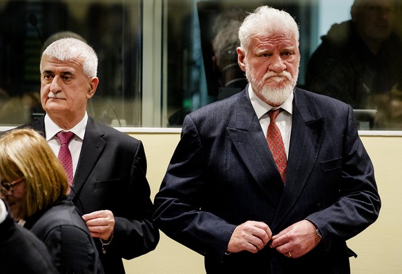Bruno Stojic and Slobodan Praljak, right, enter the Yugoslav War Crimes Tribunal in The Hague, Netherlands, Wednesday, Nov. 29, 2017, to hear the verdict in the appeals case. A United Nations war crim ...