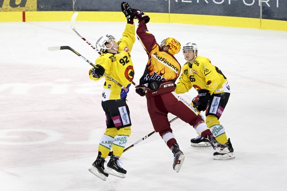 Geneve-Servette&#039;s center Tanner Richard, center, catches the puck with hand between Bern&#039;s center Gaetan Haas, left, and defender Ramon Untersander, right, during a National League regular s ...