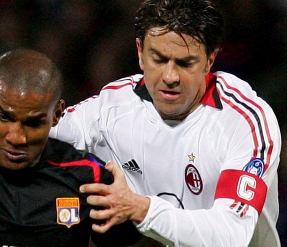 Olympic Lyon&#039;s Florent Malouda (L) fights for the ball with Alessandro Costacurta of AC Milan during their Champions League quarterfinal match at Gerland Stadium in Lyon Wednesday 29 March 2006.  ...