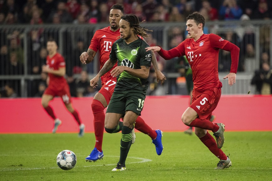 Bayern&#039;s Benjamin Pavard, right, and Wolfsburg&#039;s Kevin Mbabu battle for the ball during the Germany Bundesliga soccer match between Bayern Munich and VfL Wolfsburg at the Allianz Arena in Mu ...