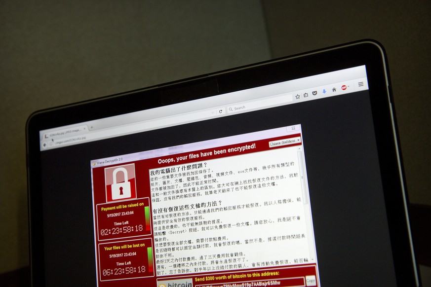 FILE - In this May 13, 2017 file photo, a screenshot of the warning screen from a purported ransomware attack, as captured by a computer user in Taiwan, is seen on laptop in Beijing. Global cyber chao ...