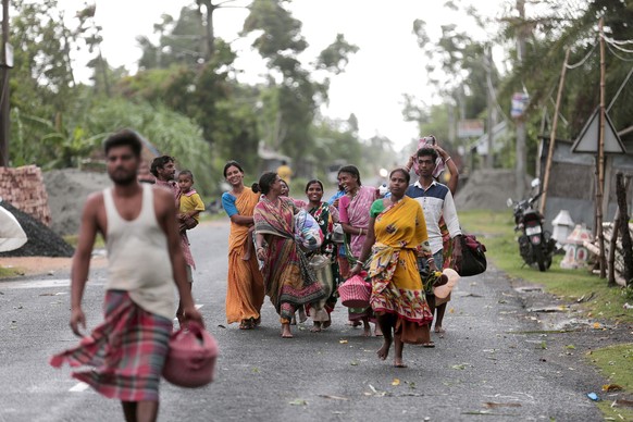 epa08432967 Indian villagers walk to a school building as they evacute before Cyclone Amphan arrives, in Balikhali village near the Bay of Bengal, India, 20 May 2020. The Odisha government and Bengal  ...