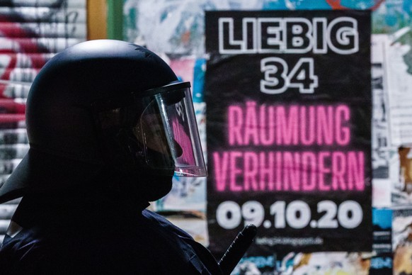 epa08730249 A police officer stands in front of a poster reading ?Liebig 34 - prevent eviction - 09.10.20? a day prior to the planned eviction of the left-wing scene living project Liebig34 (Liebig st ...