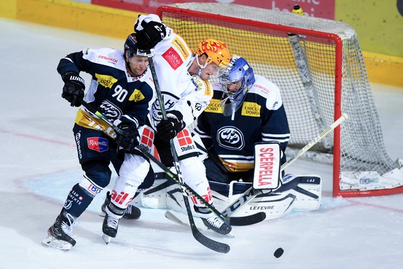 From left Ambri&#039;s player Jannik Fischer, Lugano&#039;s player Daniel Carr and Ambri&#039;s goalkeeper Benjamin Conz, during the preliminary round game of National League A (NLA) Swiss Championshi ...
