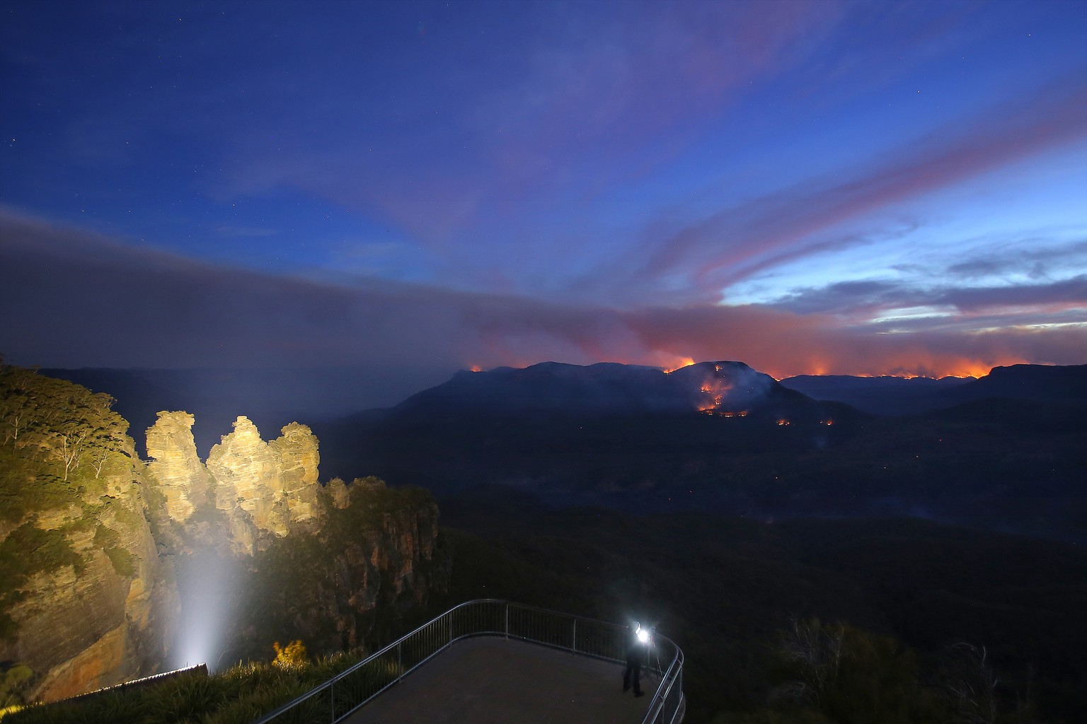 epaselect epa08048687 A long exposure photograph shows the Three Sisters rock formation as flames from the Kowmung River fire and the Green Wattle Creek fire are visible from Echo Point lookout in Kat ...