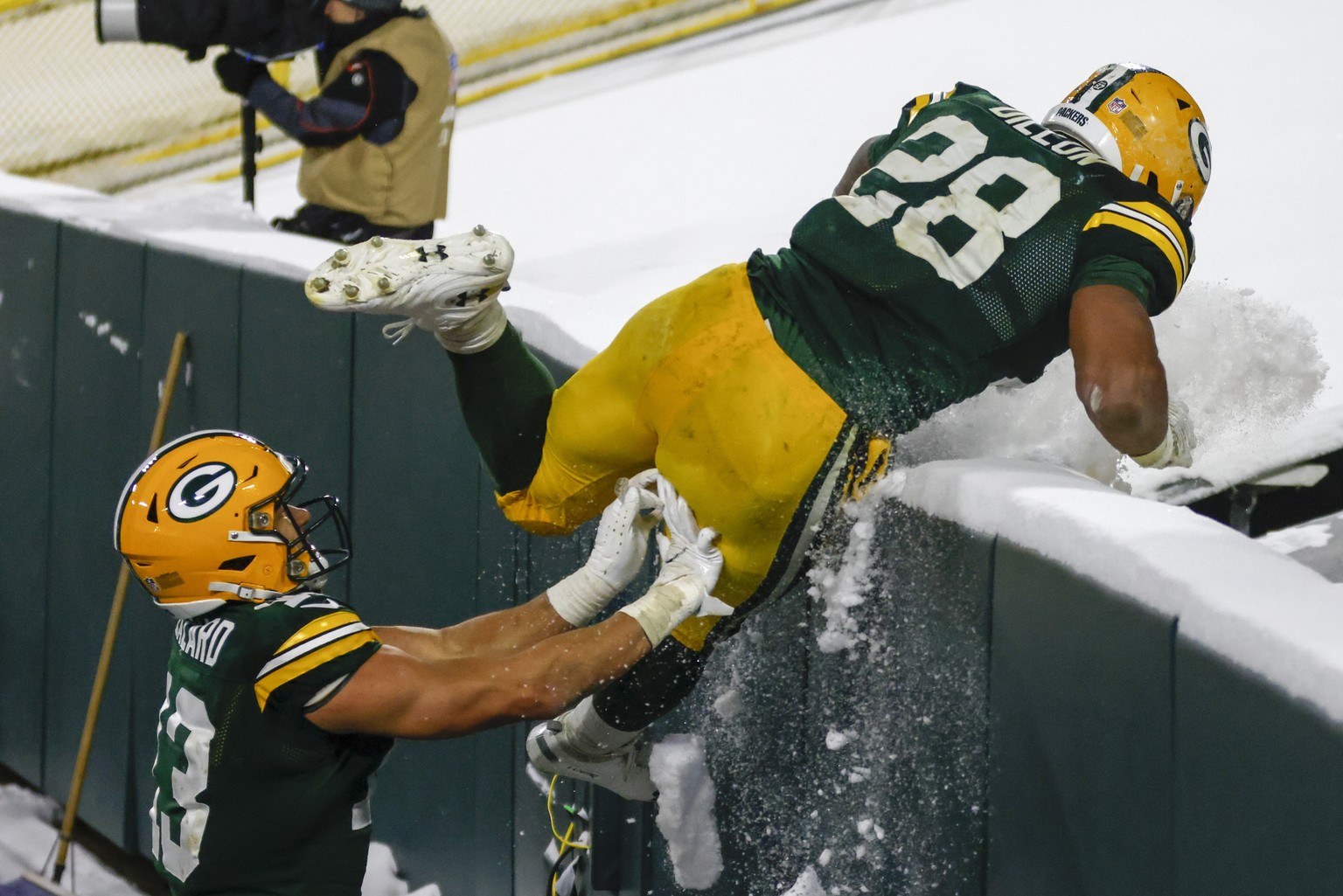 Green Bay Packers&#039; A.J. Dillon is helped by Allen Lazard to get into the stands to celebrate his touchdown run during the second half of an NFL football game against the Tennessee Titans Sunday,  ...