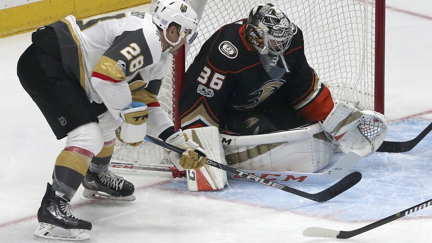 Anaheim Ducks goalie Reto Berra (1) deflects the puck as Vegas Golden Knights left winger William Carrier (28) moves in in the first period of an NHL hockey game in Anaheim, Calif., Wednesday, Nov. 22 ...
