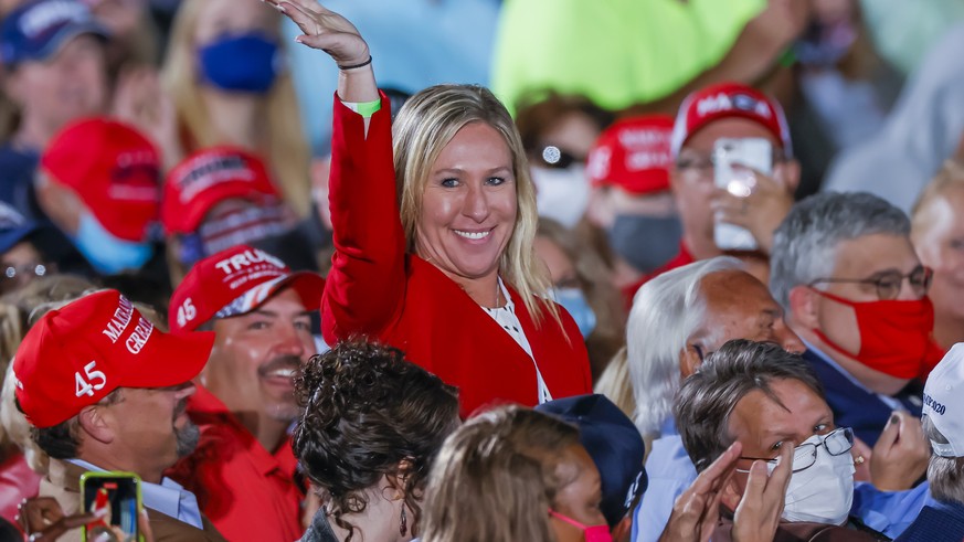 epa08751761 Republican Georgia Congressional candidate and QAnon promoter Marjorie Taylor Greene is recognized by US President Donald J. Trump as he speaks at his Make America Great Again Rally campai ...