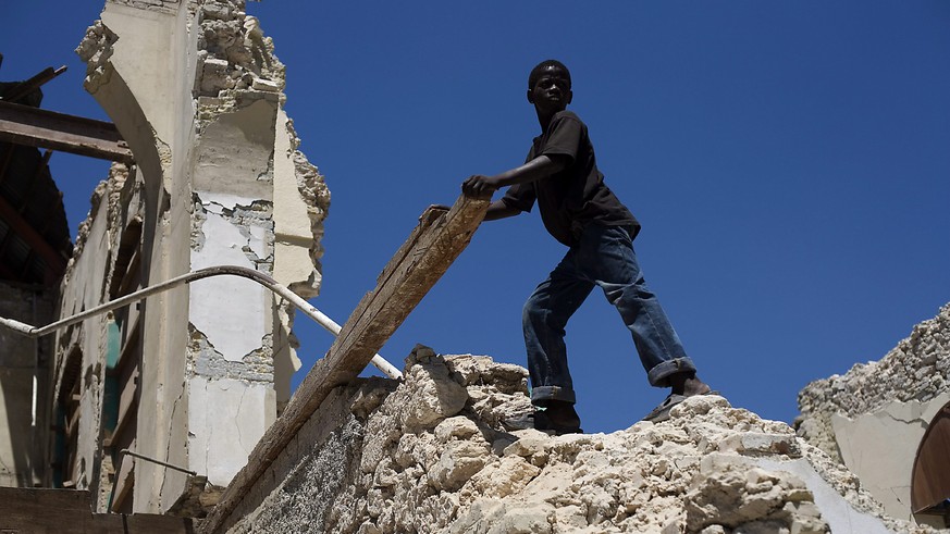 epa04557269 (FILE) A file photo dated 24 March 2010 of an Haitian earthquake surviver searching for useful items under the rubble of the ruins of the Public Work Minister&#039;s building in Port-au-Pr ...