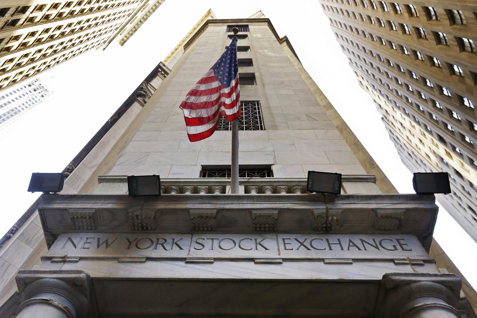 In this Friday, Nov. 13, 2015, photo, the American flag flies above the Wall Street entrance to the New York Stock Exchange, in New York. U.S. stocks wobbled between small gains and losses Tuesday, No ...