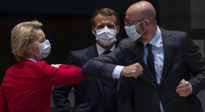 epa08553177 European Commission President Ursula von der Leyen (L) and European Council President Charles Michel (R) greet each other with an elbow bump as French President Emmanuel Macron (C) looks o ...
