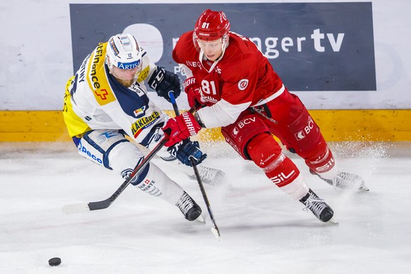 Le joueur tessinois Jiri Novotny, gauche, lutte pour le puck avec l&#039;attaquant lausannois Ronalds Kenins, droite, lors de la rencontre du championnat suisse de hockey sur glace de National League  ...