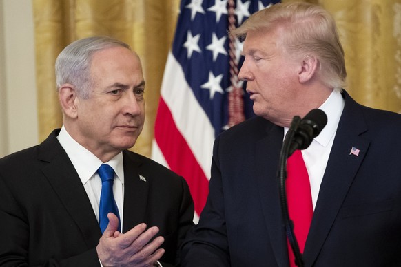 epa08173273 US President Donald J. Trump (R) speaks to Prime Minister of Israel Benjamin Netanyahu (L) while unveiling his Middle East peace plan in the East Room of the White House, in Washington, DC ...