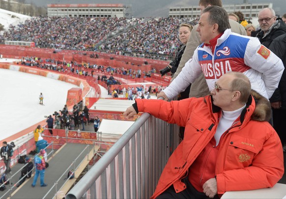 FILE - In this file photo taken Saturday, March 8, 2014, Russian President Vladimir Putin, foreground, watches downhill ski competition of the 2014 Winter Paralympics in Roza Khutor mountain district  ...