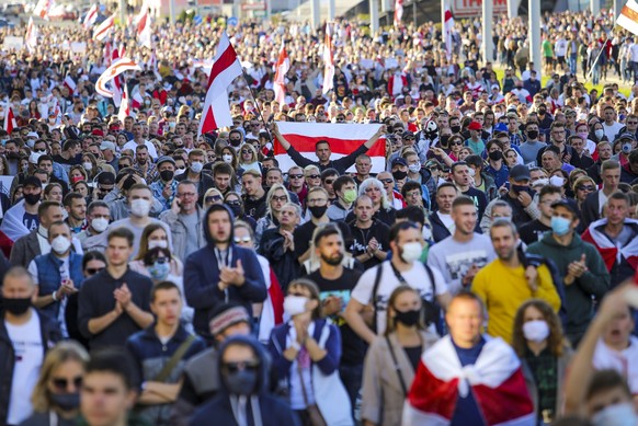 Protesters with old Belarusian national flags march during an opposition rally to protest the official presidential election results in Minsk, Belarus, Sunday, Sept. 20, 2020. Protests calling for the ...