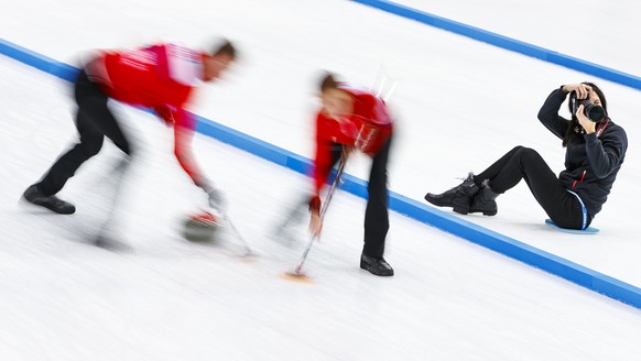 A photographer works on the ice during the bronze medal game between Norway and the Czech Republic at the World Mixed Curling Championship (WMCC) at the Palladium Ice Arena, in Champery, Switzerland,  ...