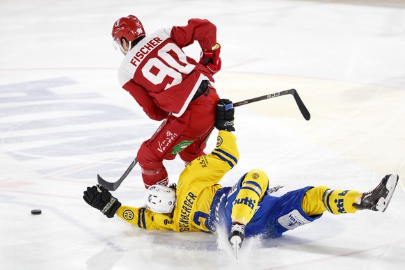 Le defenseur lausannois Jannik Fischer, gauche, lutte pour le puck avec l&#039;attaquant davosien Nando Eggenberger, droite, lors de la rencontre du championnat suisse de hockey sur glace de National  ...