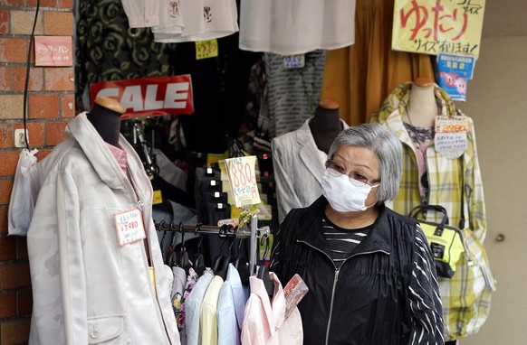 epa08340658 An elderly woman wearing a face mask shops at a clothing store at Sugamo district in Tokyo, Japan, 03 April 2020. Despite the rise of infection cases, Japan&#039;s Prime Minister Shinzo Ab ...