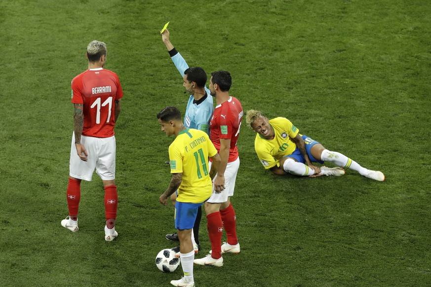 Mexican referee Cesar Arturo Ramos, center, shows the yellow card to Switzerland&#039;s Valon Behrami, left, as Brazil&#039;s Neymar reacts during the group E match between Brazil and Switzerland at t ...