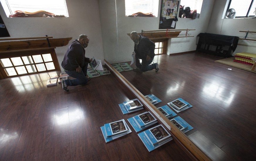 School employee Joel Barbas organizes textbooks for parents to pick up, in a room of the empty Casa del Colibri school amid the new coronavirus pandemic, as students return to classes but not schools  ...