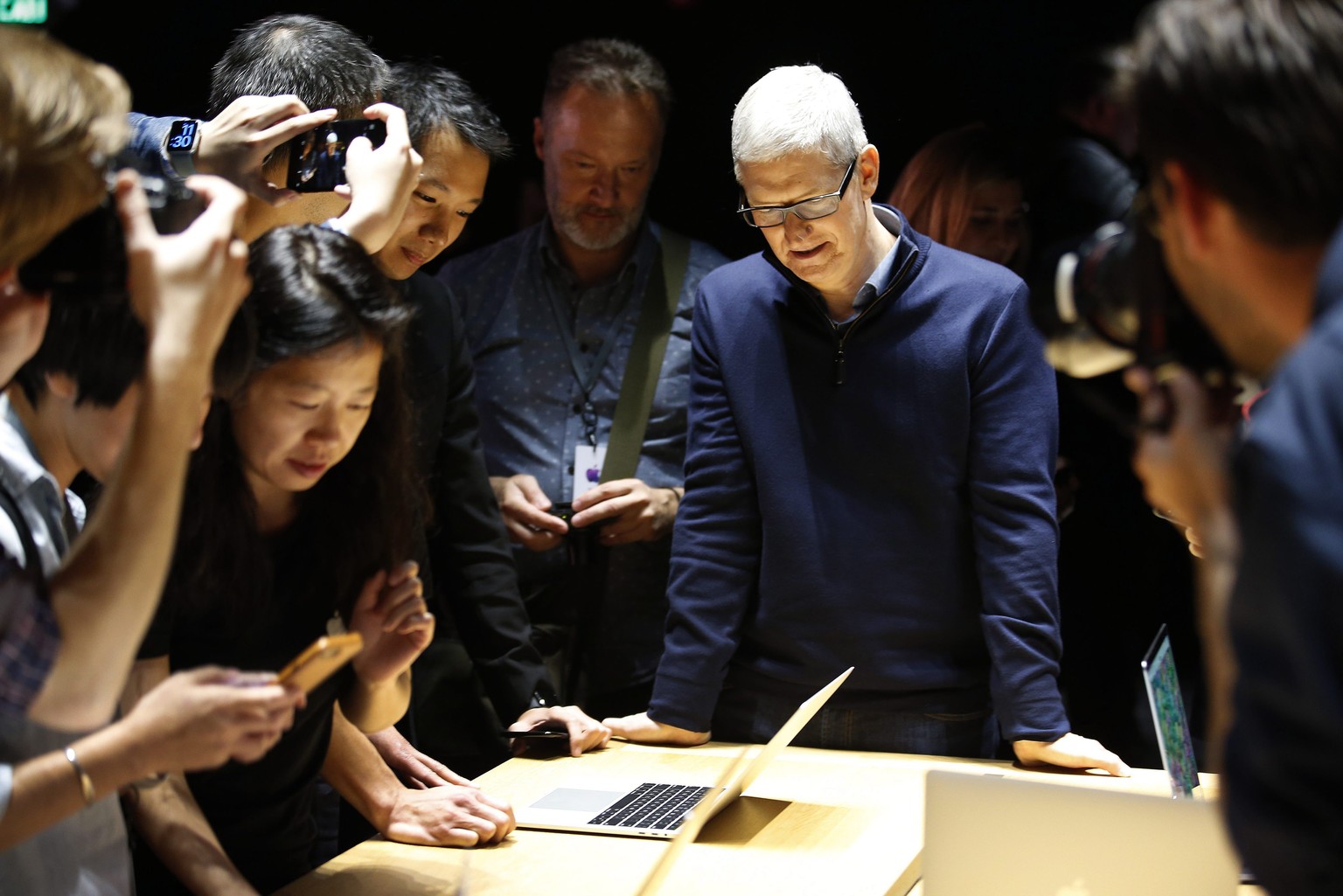 epaselect epa05606203 Tim Cook, CEO of Apple Inc., looks on as guests inspect the new MacBook Pro computer shown in a demo room, following the announcement of new products at the Apple Headquarters in ...