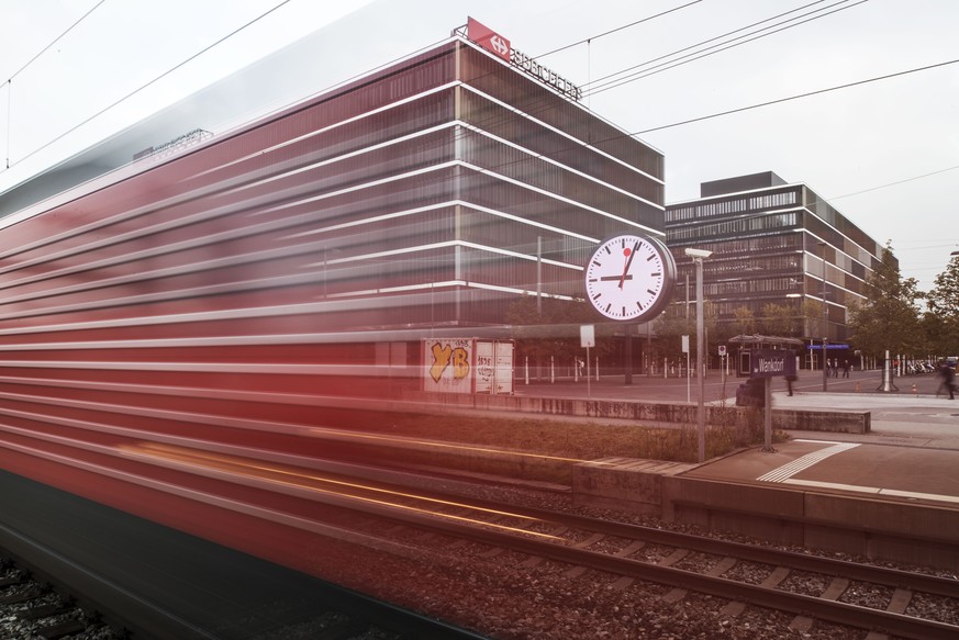 ZUM 75-JAEHRIGEN JUBILAEUM DER SBB BAHNHOFUHR (1944) STELLEN WIR IHNEN FOLGENES BILDMATERIAL ZUR VERFUEGUNG --- A train passes a large station clock in front of the new company headquarters of Swiss F ...