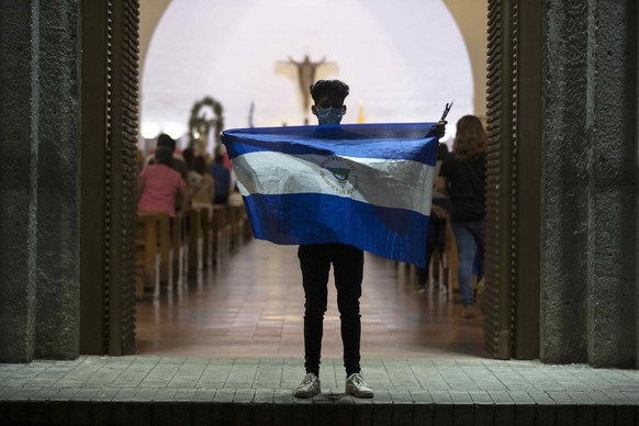 epa07894200 A man holds the Nicaraguan national flag during a vigil to demand the release of alleged political prisoners, in Managua, Nicaragua, 03 October 2019. The courtyard of ManaguaÄôs Metropoli ...