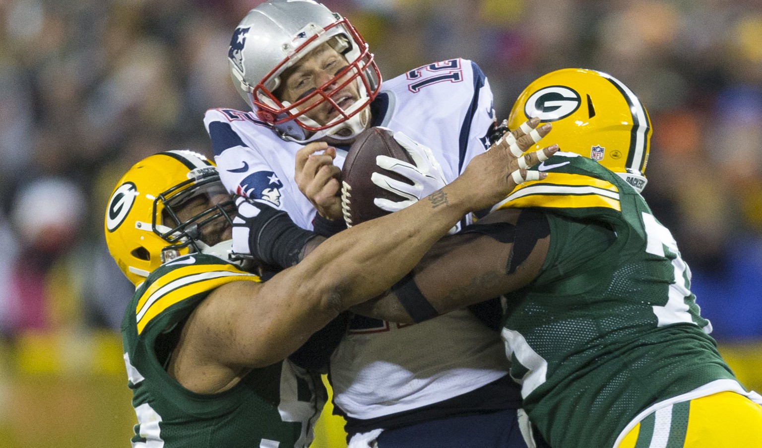 Nov 30, 2014; Green Bay, WI, USA; New England Patriots quarterback Tom Brady (12) is sacked by Green Bay Packers defensive end Mike Neal (96) and defensive end Mike Daniels (76) during the fourth quar ...