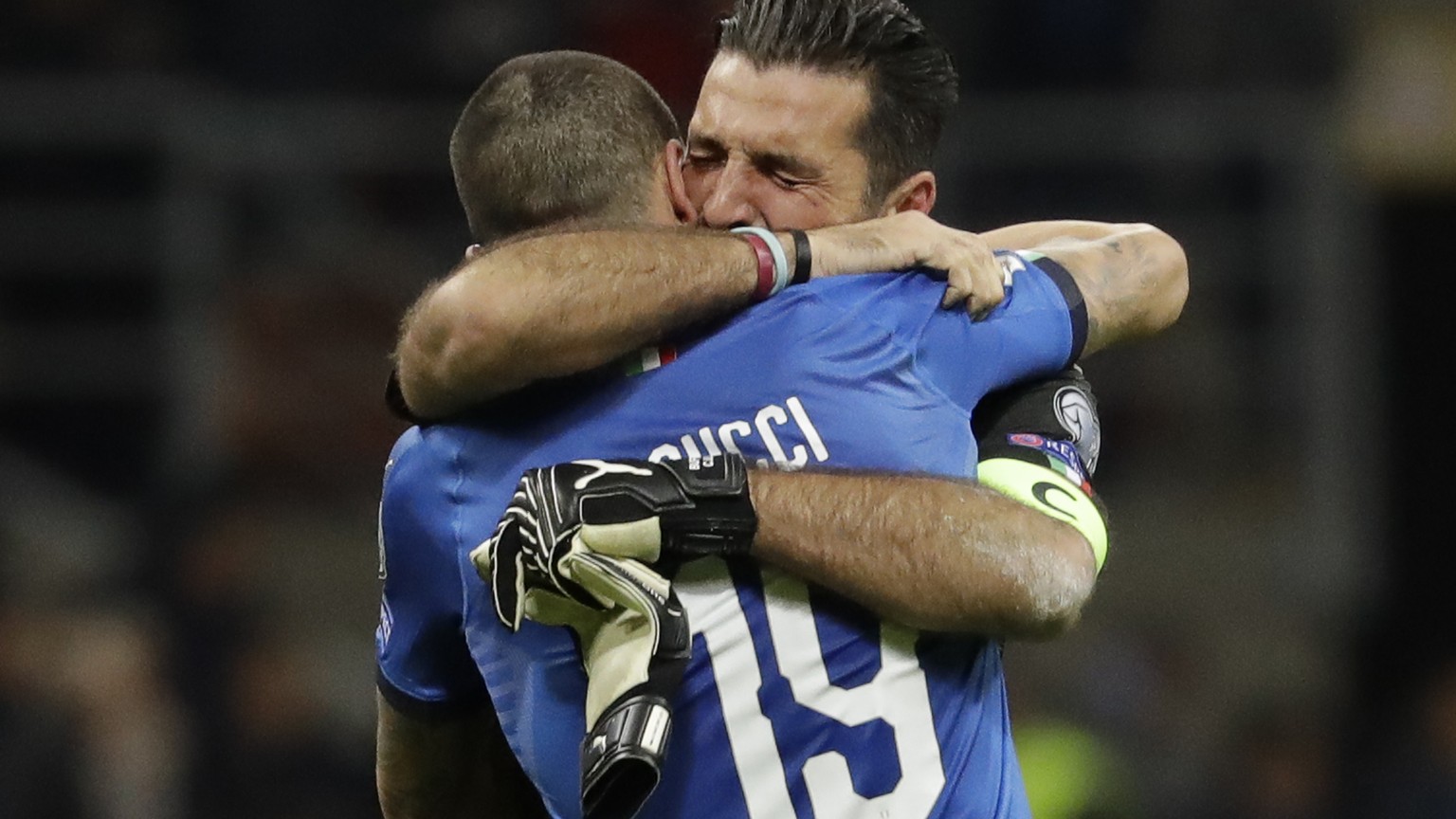 Italy goalkeeper Gianluigi Buffon is hugged by teammate Leonardo Bonucci after their team was eliminated in the World Cup qualifying play-off second leg soccer match between Italy and Sweden, at the M ...