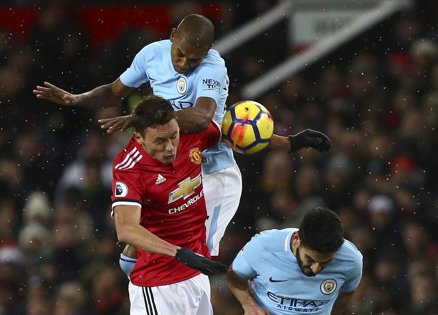 Manchester United&#039;s Nemanja Matic, left, jumps for the ball with Manchester City&#039;s Fernandinho and Ilkay Gundogan, right, during the English Premier League soccer match between Manchester Un ...