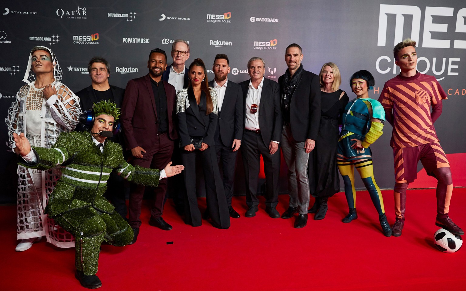 epa07911255 FC Barcelona&#039;s forward Lionel Messi (6-R) from Argentina and his wife Antonela Rocuzzo (7-R) pose for the media with Cirque du Soleil members upon arrival to the premiere of the Cirqu ...