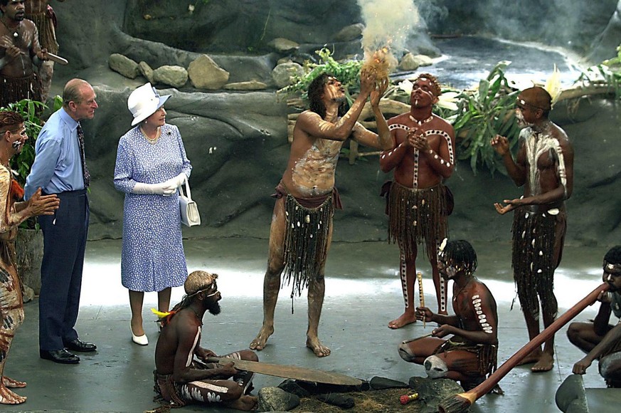 Britain&#039;s Queen Elizabeth II and Prince Philip watch as Warren Clements of the Tjapakai Aboriginal Dance Group makes fire by rubbing sticks in Cairns, Australia, Friday, March 1, 2002. (AP Photo/ ...