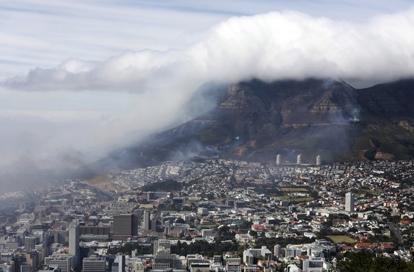 Clouds of smoke are seen above the city of Cape Town, South Africa, Monday, April 19, 2021. Residents are being evacuated from Cape Town neighborhoods after a huge fire spreading on the slopes of the  ...