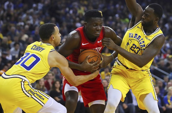 Houston Rockets&#039; Clint Capela, center, keeps the ball from Golden State Warriors&#039; Stephen Curry, left, and Draymond Green (23) during the first half of an NBA basketball game Thursday, Jan.  ...