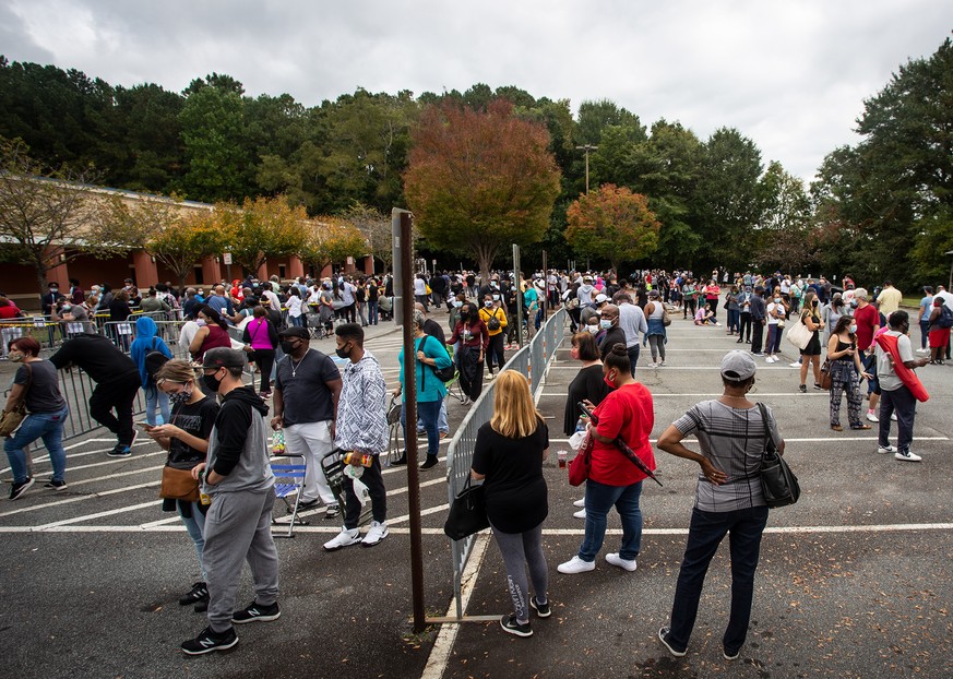 Hundreds of people wait in line for early voting on Monday, Oct. 12, 2020, in Marietta, Georgia. Eager voters have waited six hours or more in the former Republican stronghold of Cobb County, and line ...
