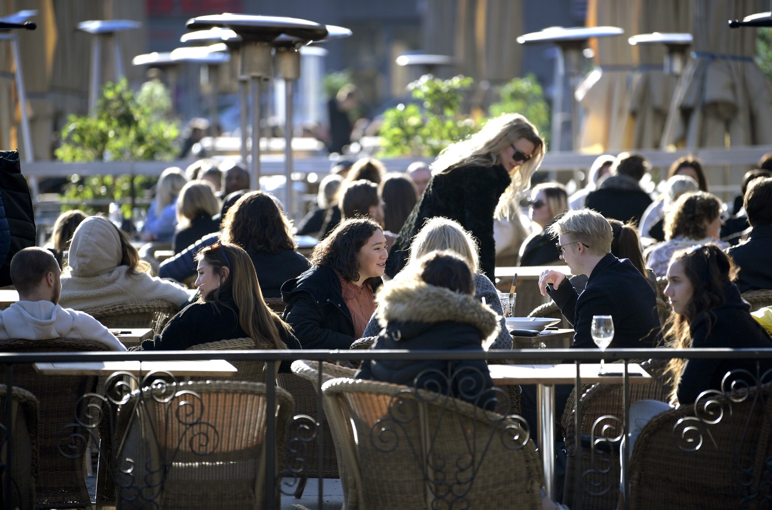 epa08324734 People sit at an outdoor restaurant at a square in central Stockholm, Sweden, 26 March 2020. Despite the coronavirus outbreak around the world, people gather to enjoy the sun. EPA/Janerik  ...