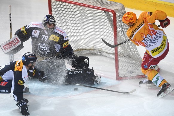 Ambri&#039;s goalkeeper Daniel Manzato, left, fights for the puck with Tiger&#039;s player Harri Pesonen, right, during the preliminary round game of National League between HC Ambri Piotta and SCL Ti ...