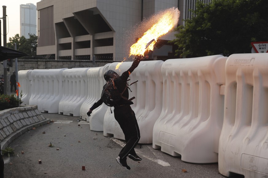 An anti-government protester throws a Molotov cocktail during a demonstration near Central Government Complex in Hong Kong, Sunday, Sept. 15, 2019. Police fired a water cannon and tear gas at proteste ...
