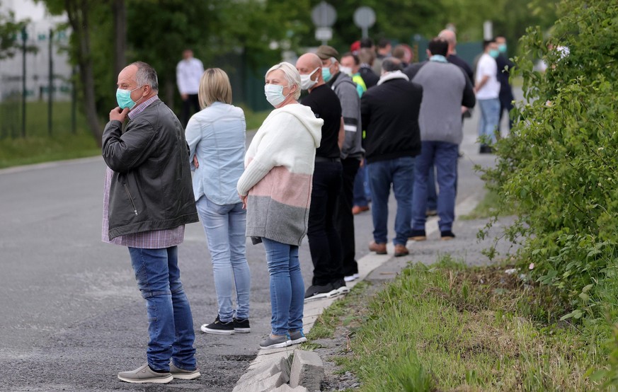 epa08413193 Employees queue for a coronavirus test at a testing station on the factory premises of the Westfleisch meat processing company in Hamm, Germany, 10 May 2020. A large-scale corona test was  ...