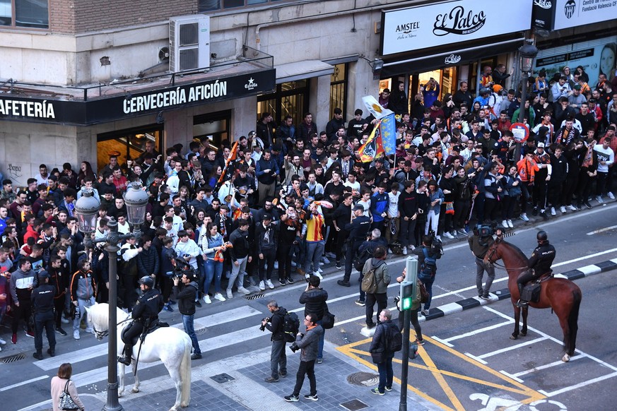 epa08284211 A handout image provided by UEFA shows fans waiting behind a line of police outside the stadium ahead of the UEFA Champions League round of 16 second leg match between Valencia CF and Atal ...