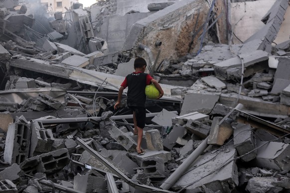 epa06938462 A child stands in the rubble of Said al-Mishal Cultural Center building destroyed in Israeli air strike in the west of Gaza City in Gaza, 09 August 2018. According to reports, 18 Palestini ...