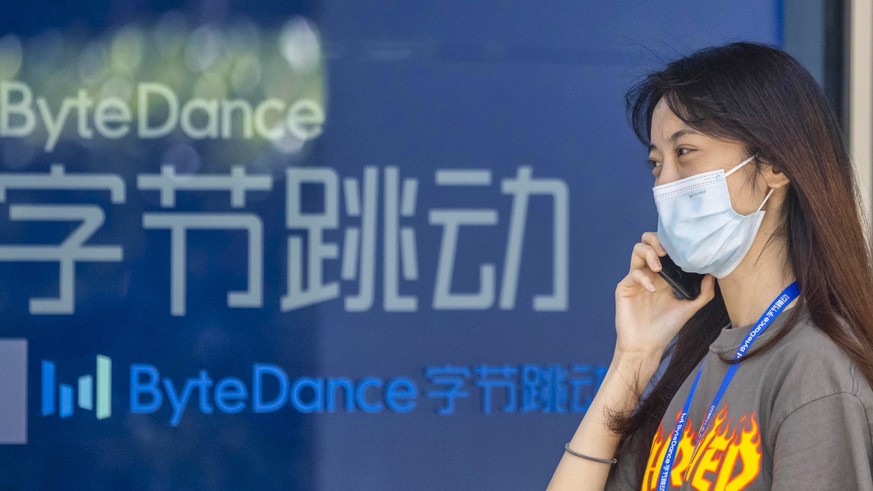 epa08581690 A woman uses her phone in front of the Bytedance headquarters building in Shanghai, China, 03 August 2020. According to media reports, Microsoft is in talks to buy the US operations of Chi ...